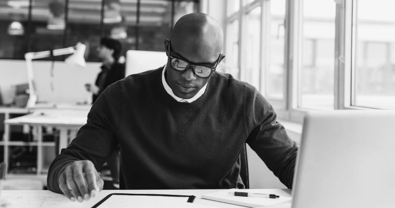A man looking at financial documents at his desk